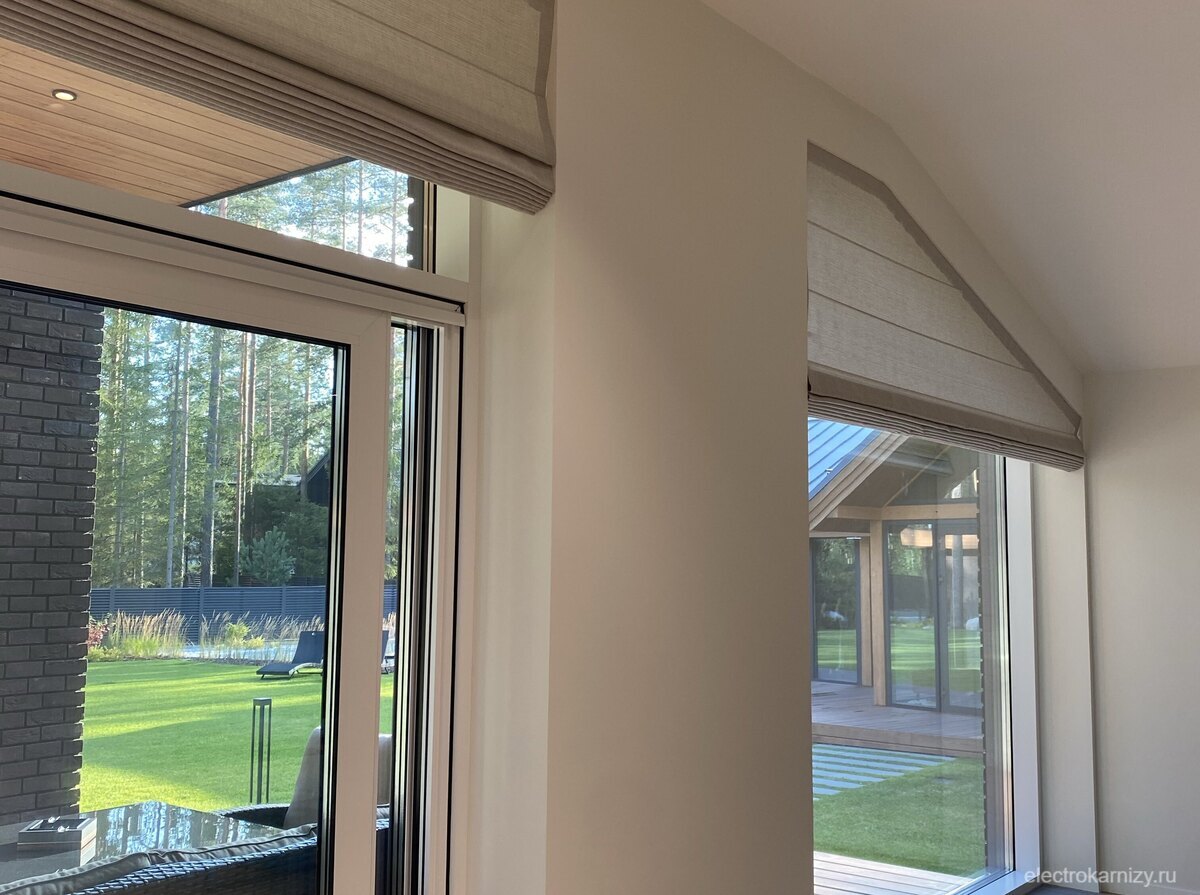 Элегантная римская штора, поднятая вертикально на наклонном окне в спальне